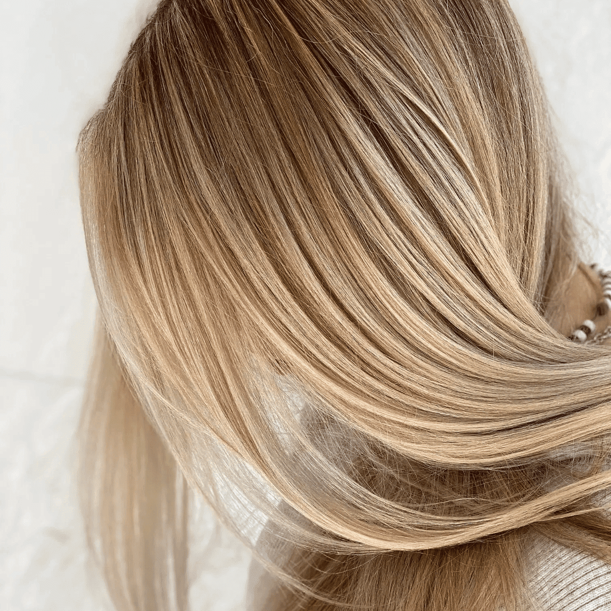 Close-up of smooth, blonde hair with layered highlights.